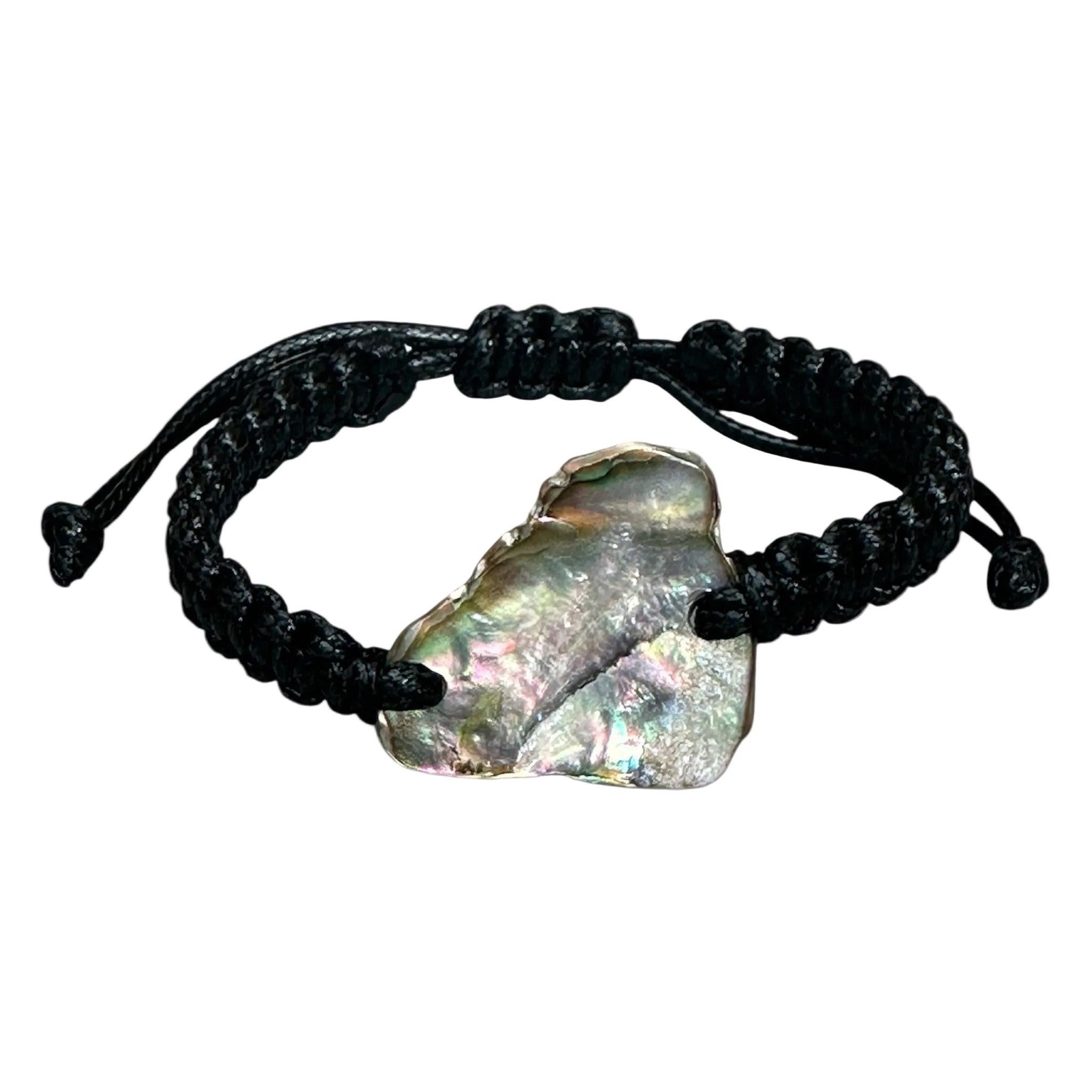 Detail shot of Paua shell set in black knotted cord, with focus on the shell’s natural colour variations.